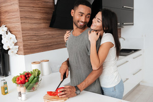 graphicstock image of happy young couple in the kitchen hugging while