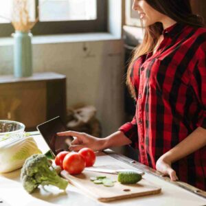 graphicstock cropped image of woman in red shirt standing in kitchen with tablet computer and looking recipes side view BLIeriD7Ohl 1 scaled 1